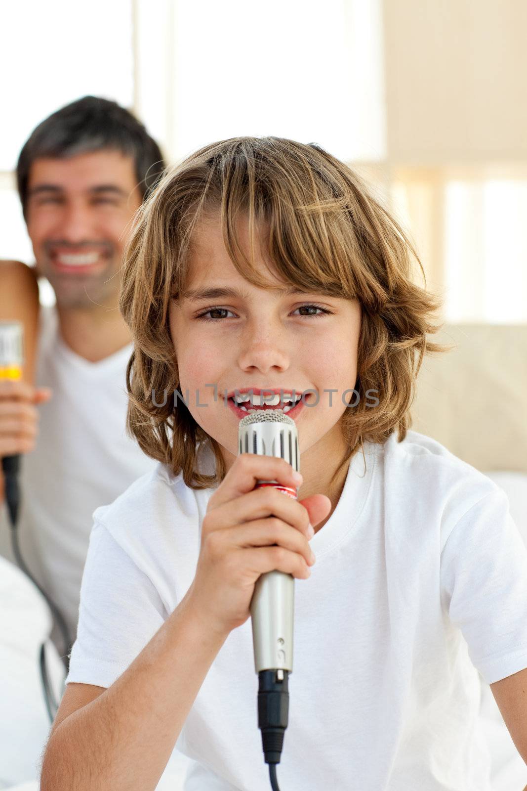 Little boy singing with a microphone by Wavebreakmedia