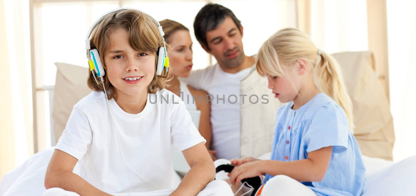 Smiling siblings listening music with headphones at home