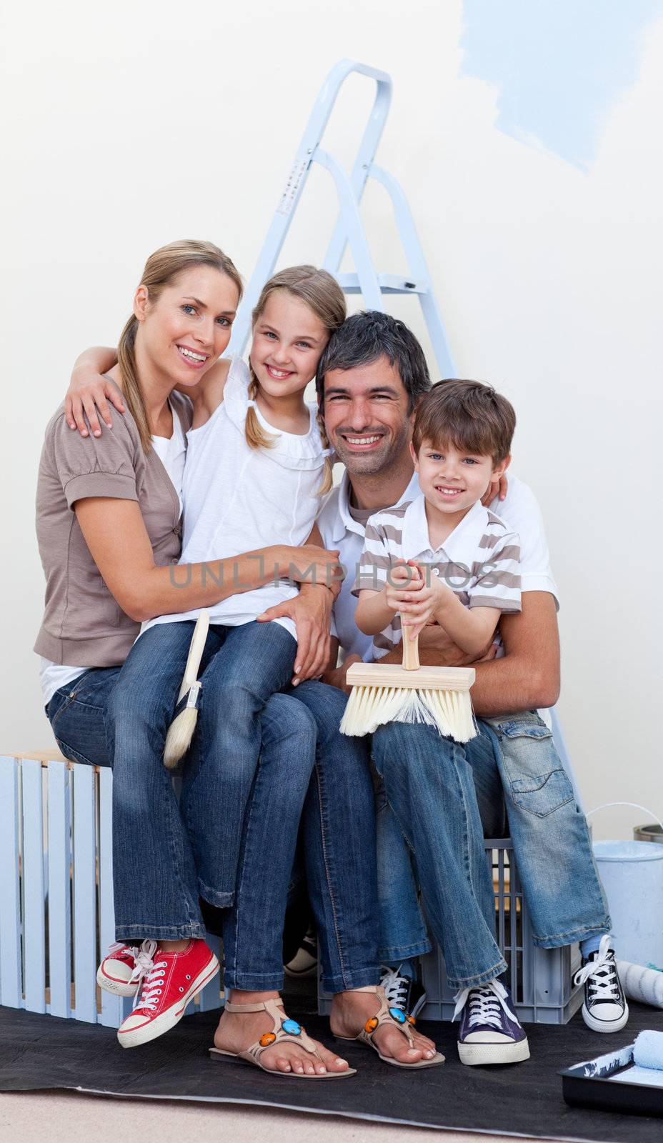 Portrait of a happy family decorating a room  by Wavebreakmedia