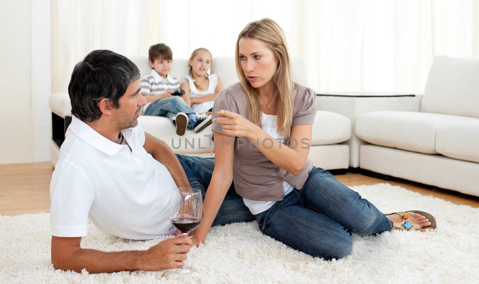 Intimate couple talking with glasses of wine lying on the floor