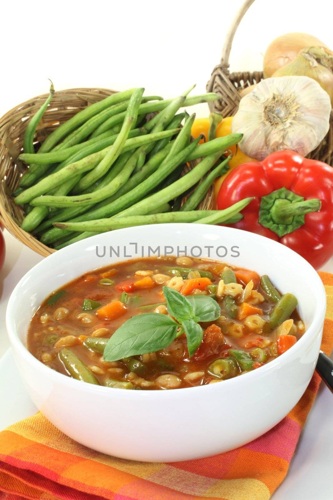 a bowl of minestrone soup and basil