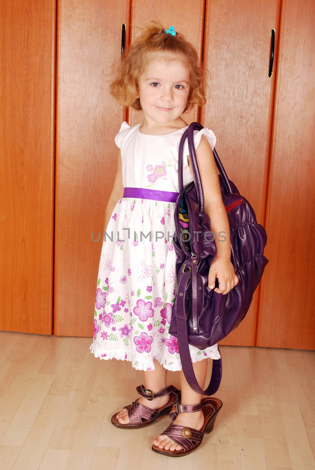 Beauty little girl with big bag and shoes