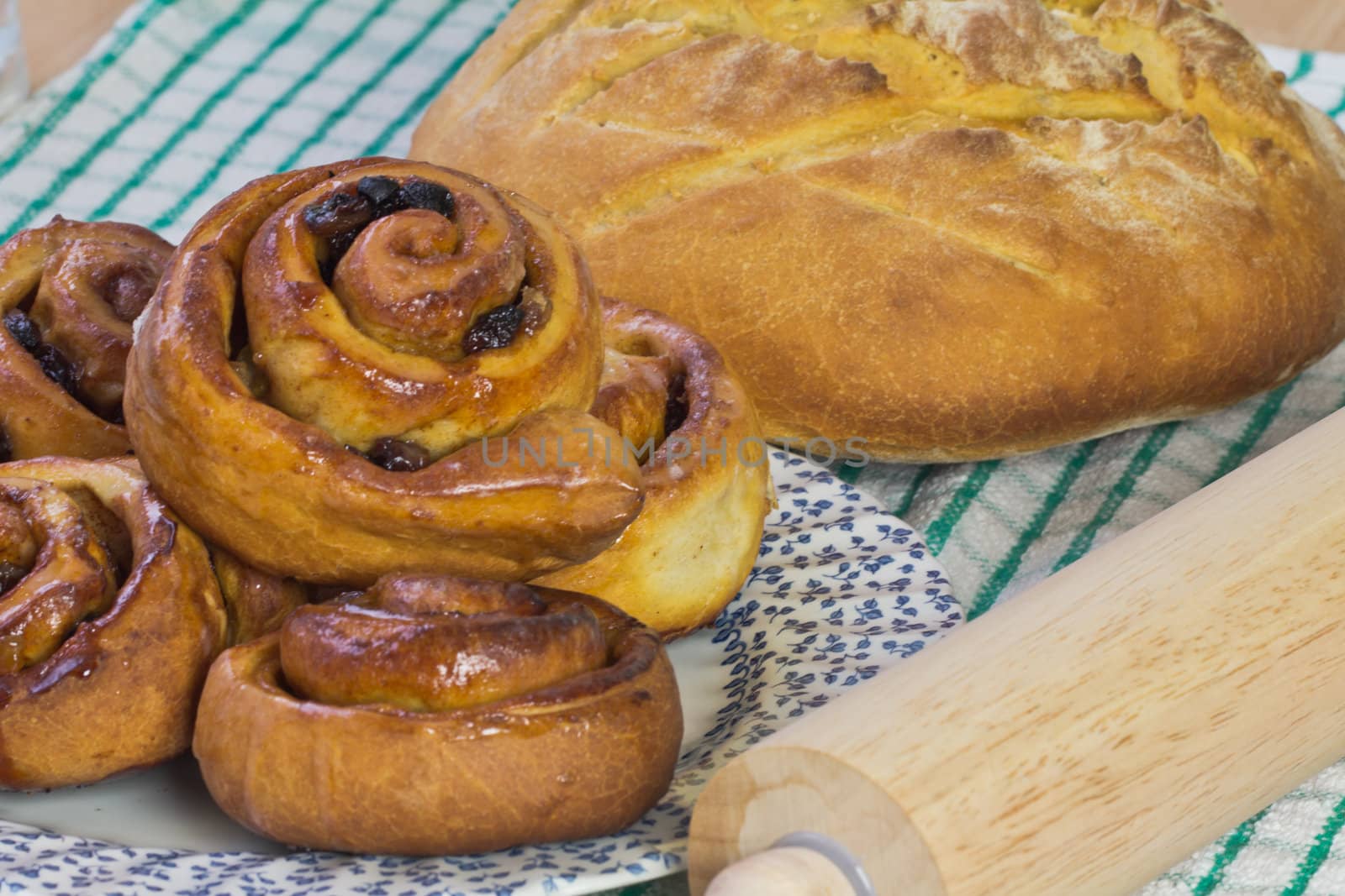 Fresh homebaked bread and buns with a rolling pin