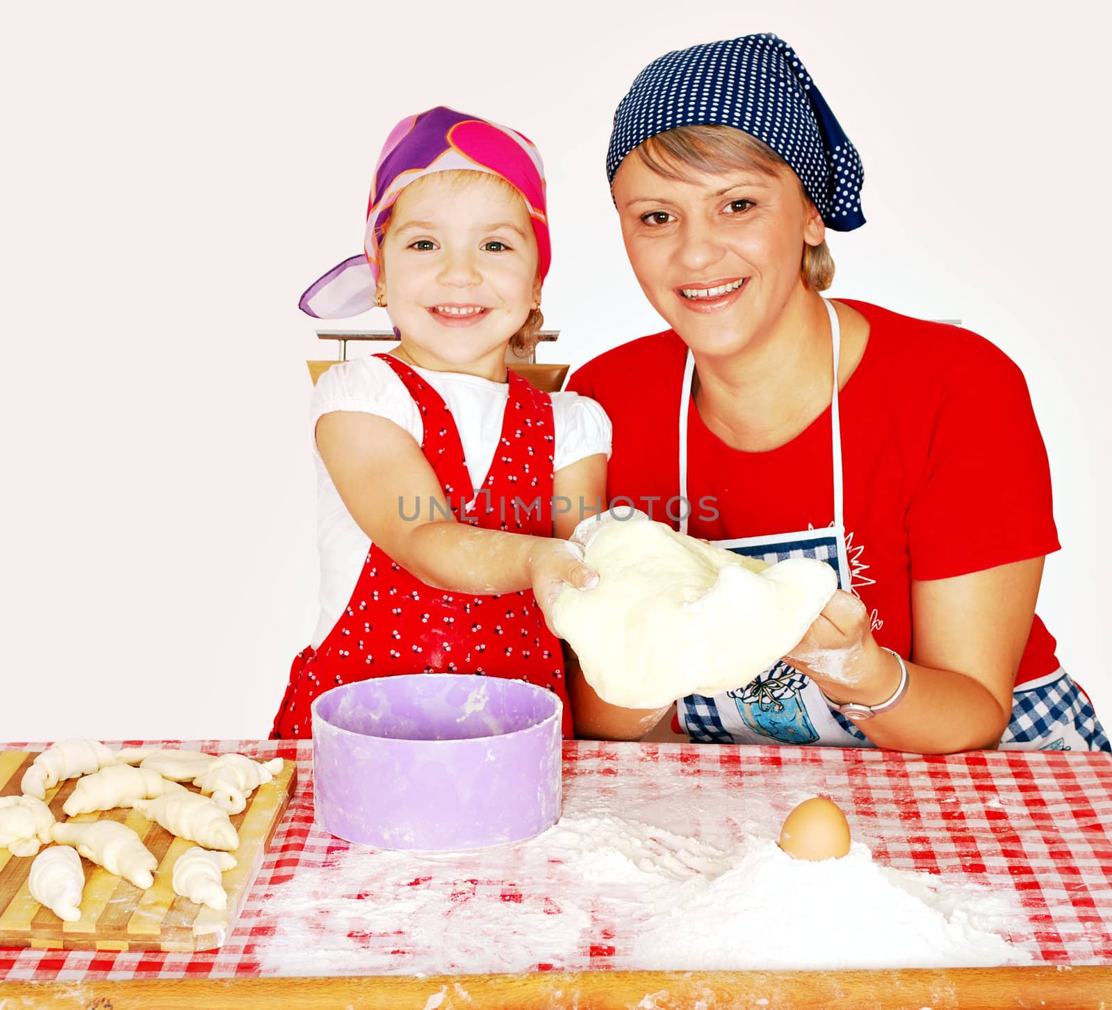 Mother and daughter make croissants studio shot