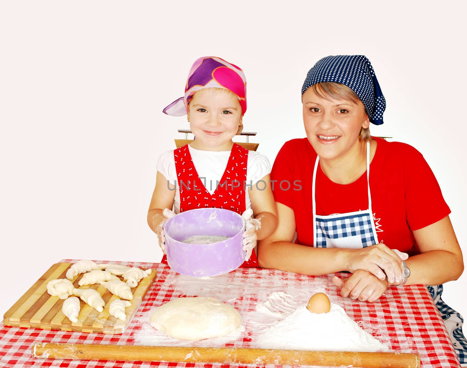 Mother and daughter make rolls with flour studio shot