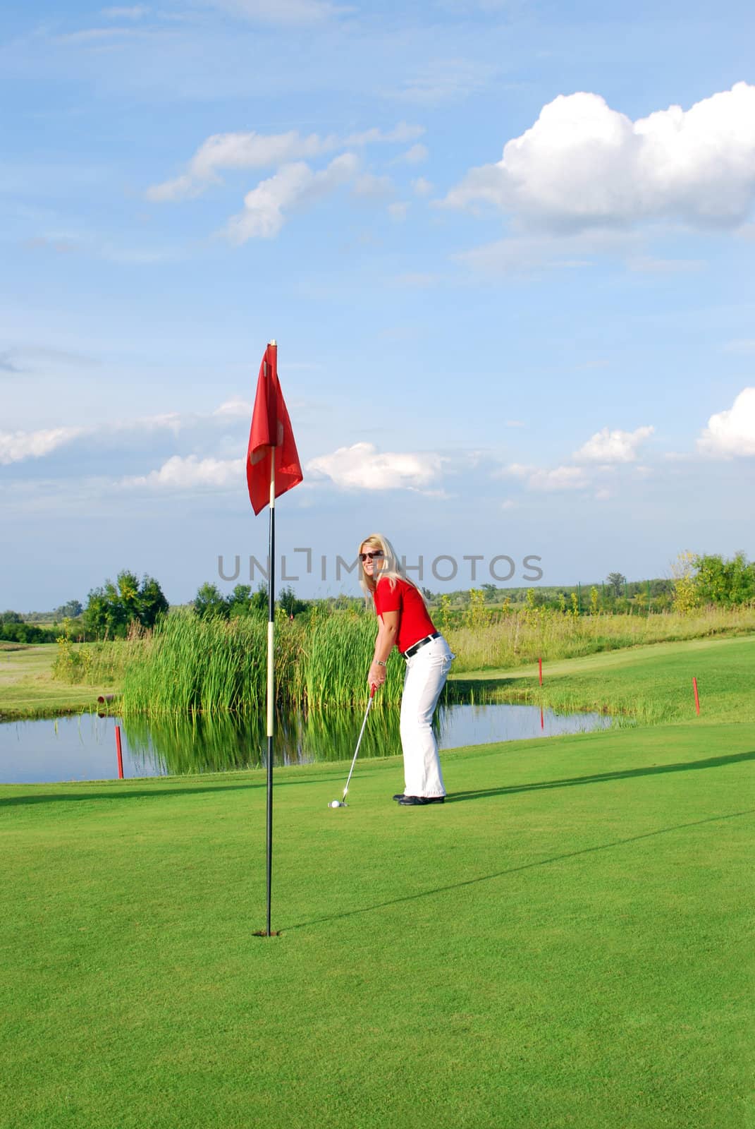 Beauty blonde girl playing golf