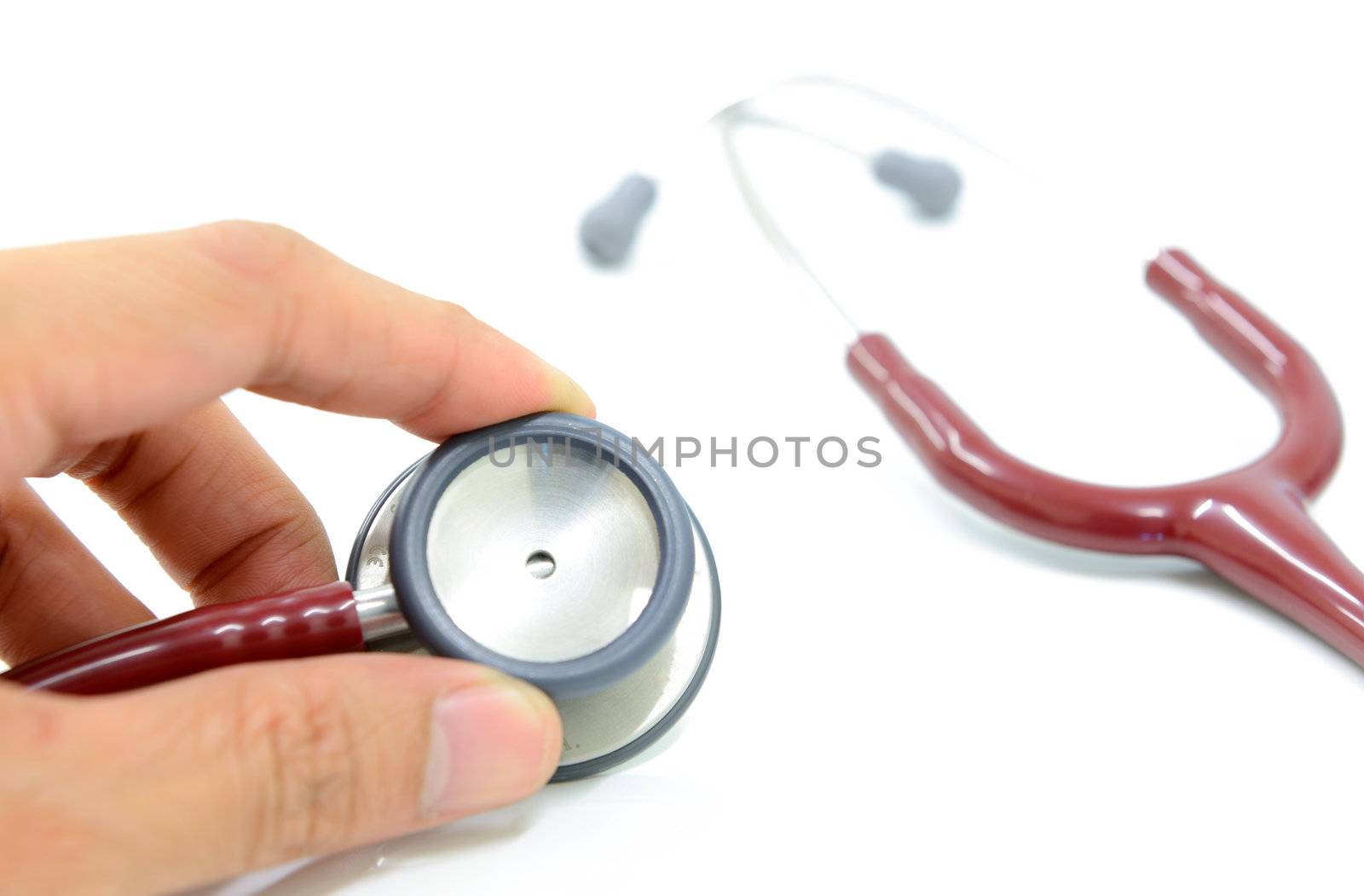 The doctor hand is holding stethoscope, isolated on the white background.