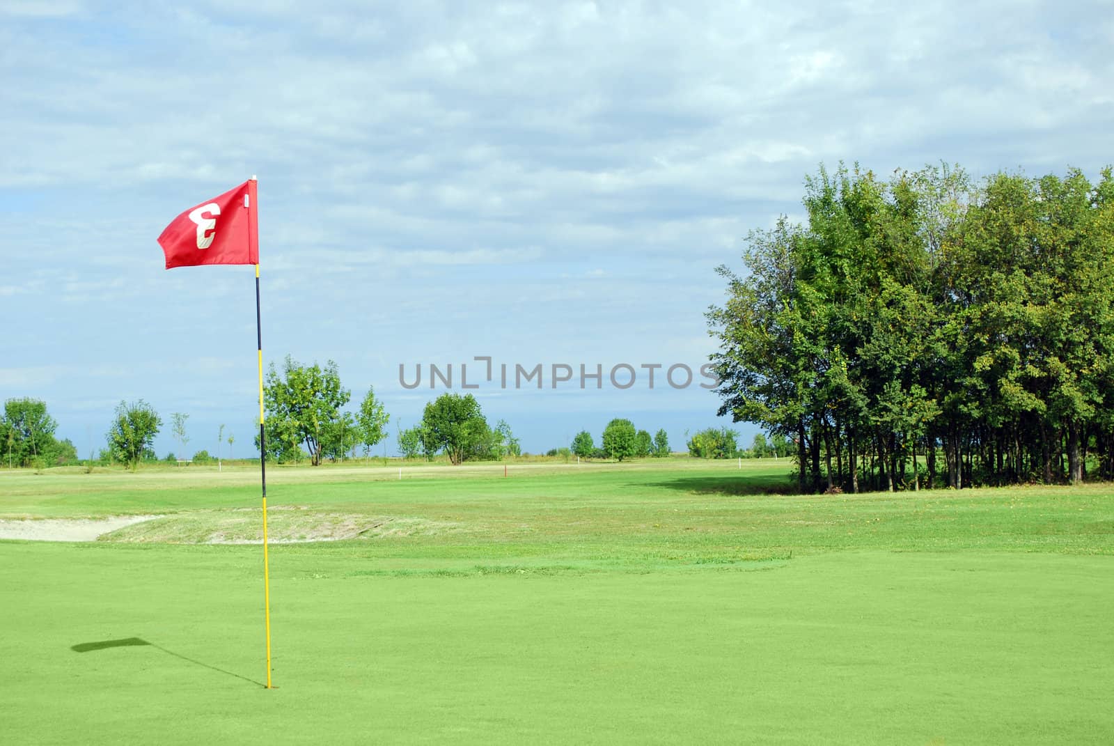 Golf course with red flag number three