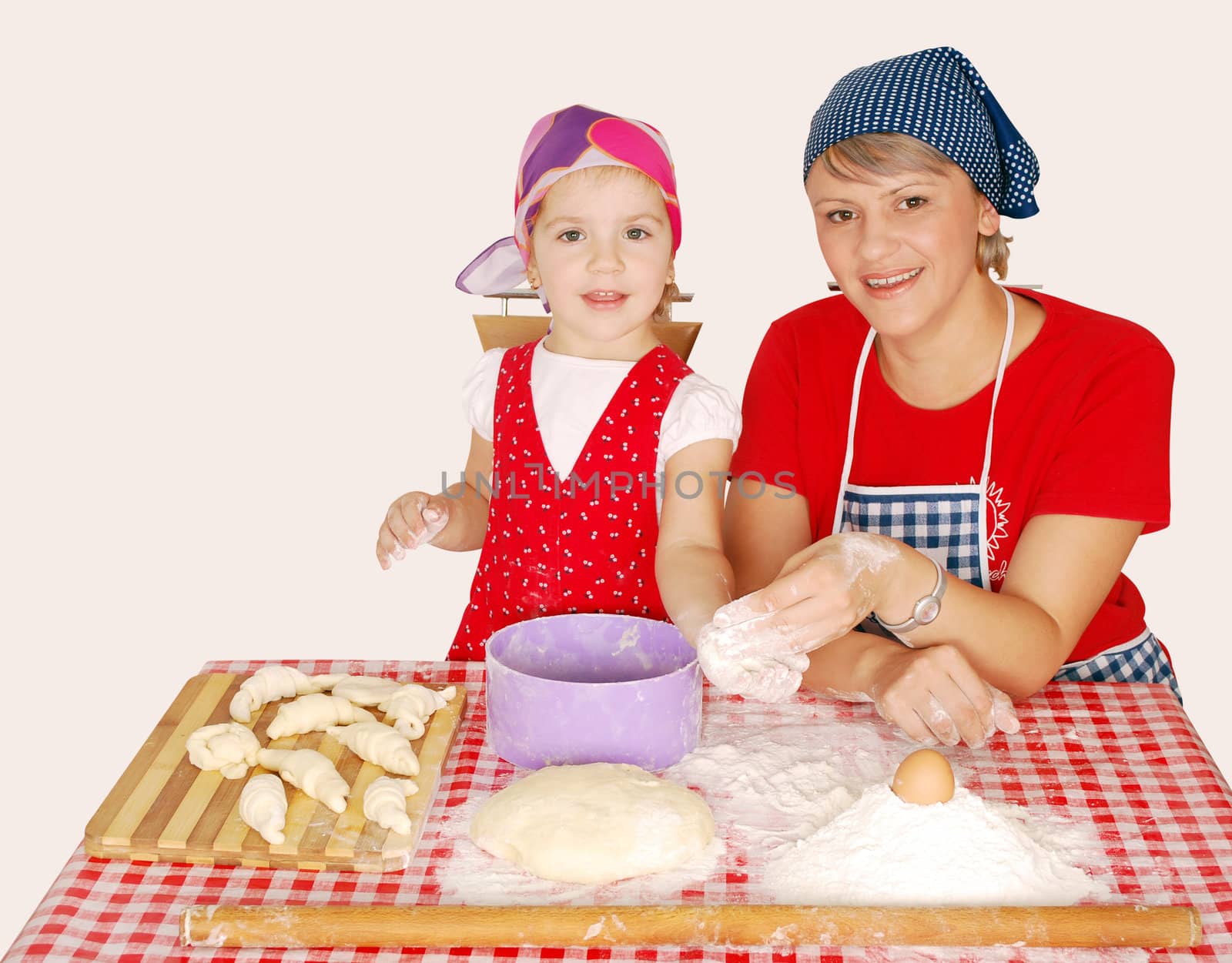 Mother and daughter with flour and rolls