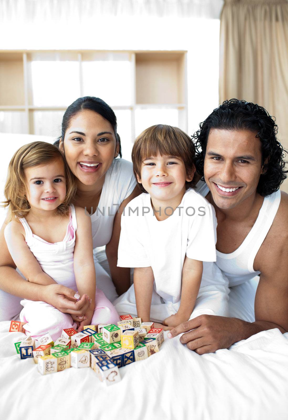 Happy family having fun with cube toys in the bedroom