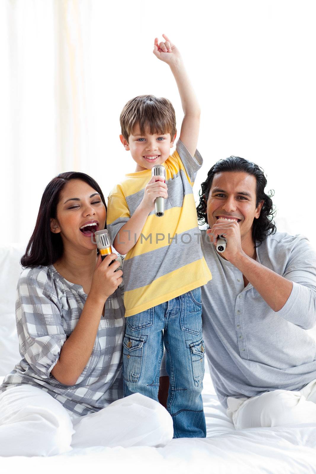 Lively young family singing with microphones at home