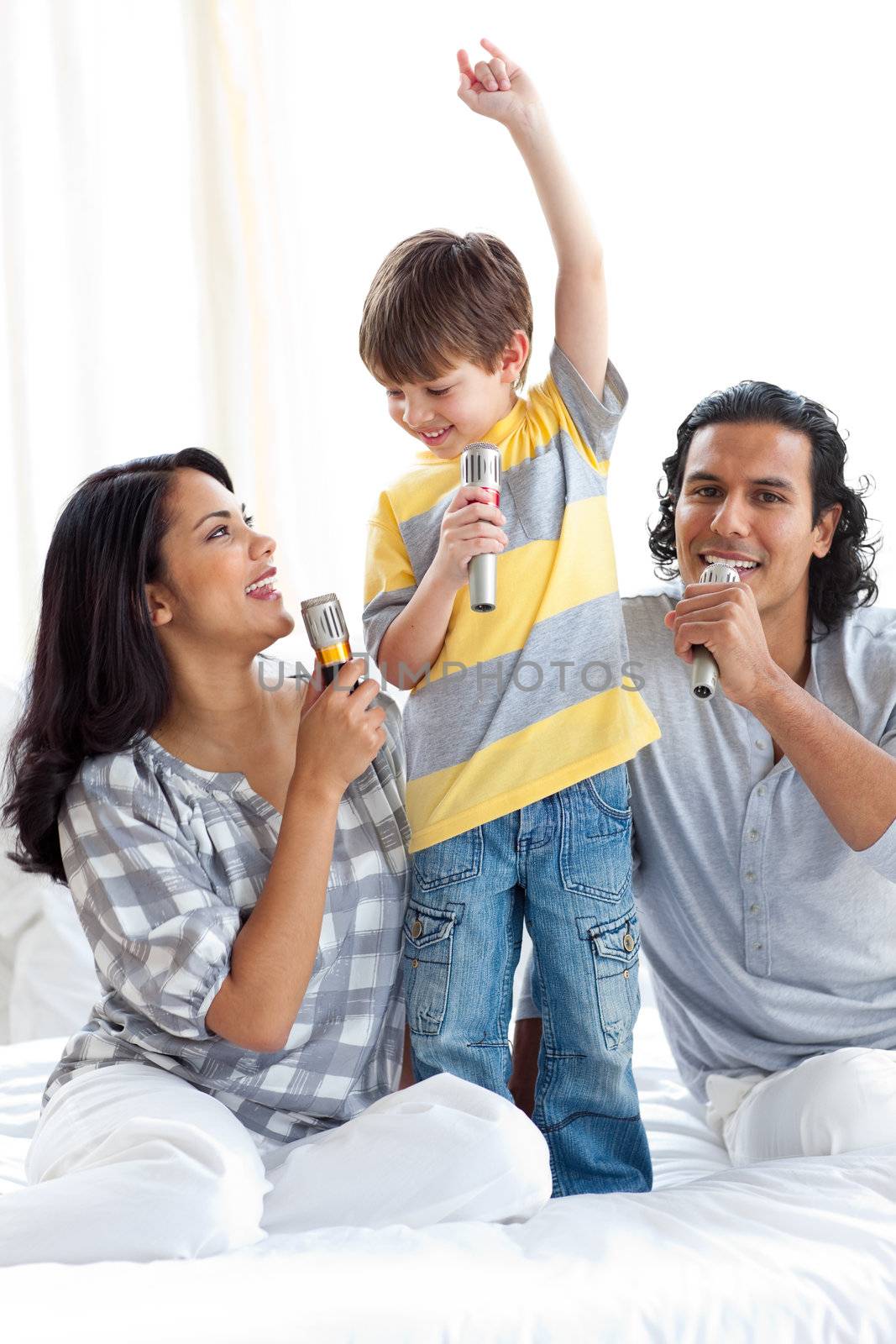 Adorable little boy singing with his parents  by Wavebreakmedia