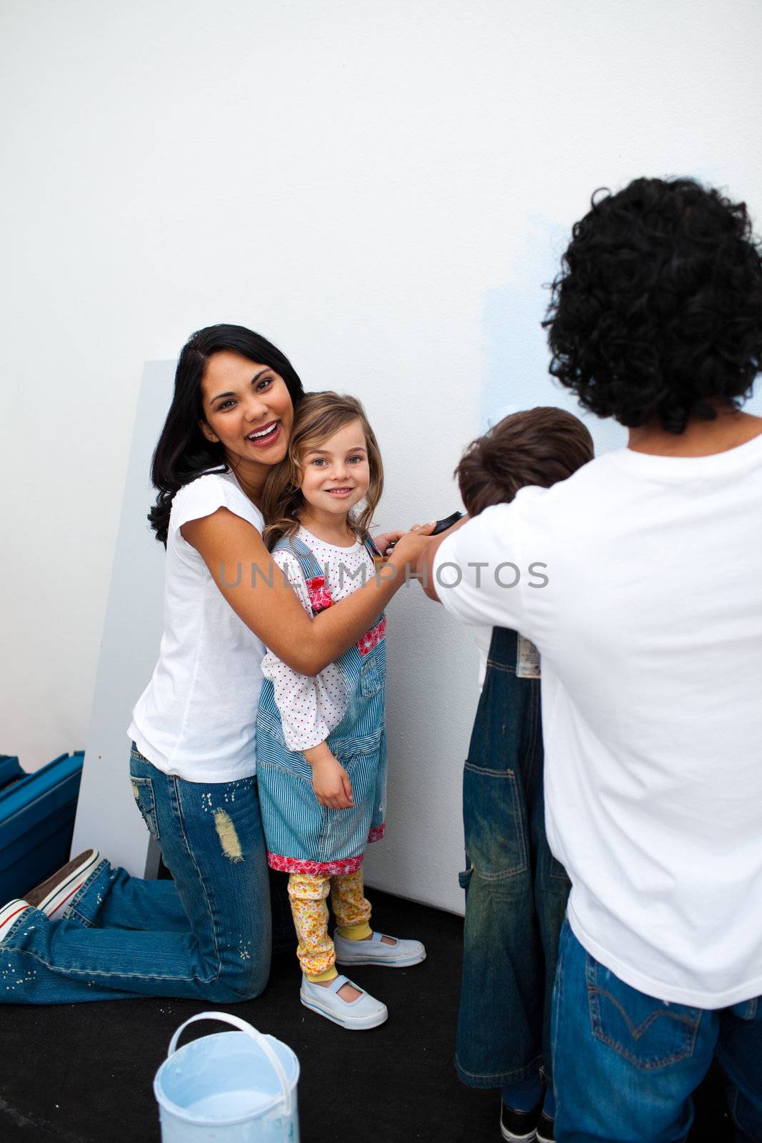 Jolly parents with their children painting a room  by Wavebreakmedia