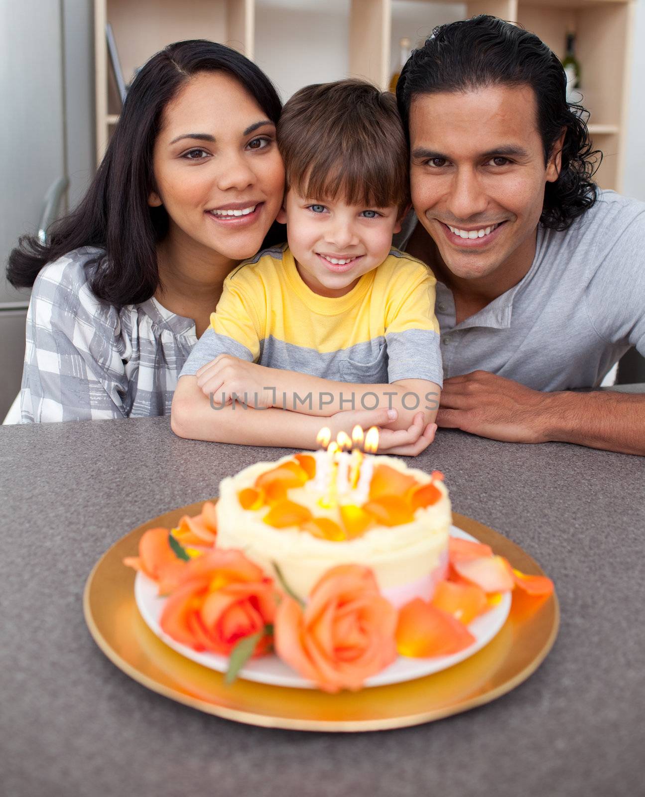 Attentive parents celebrating their son's birthday in the kitchen by Wavebreakmedia