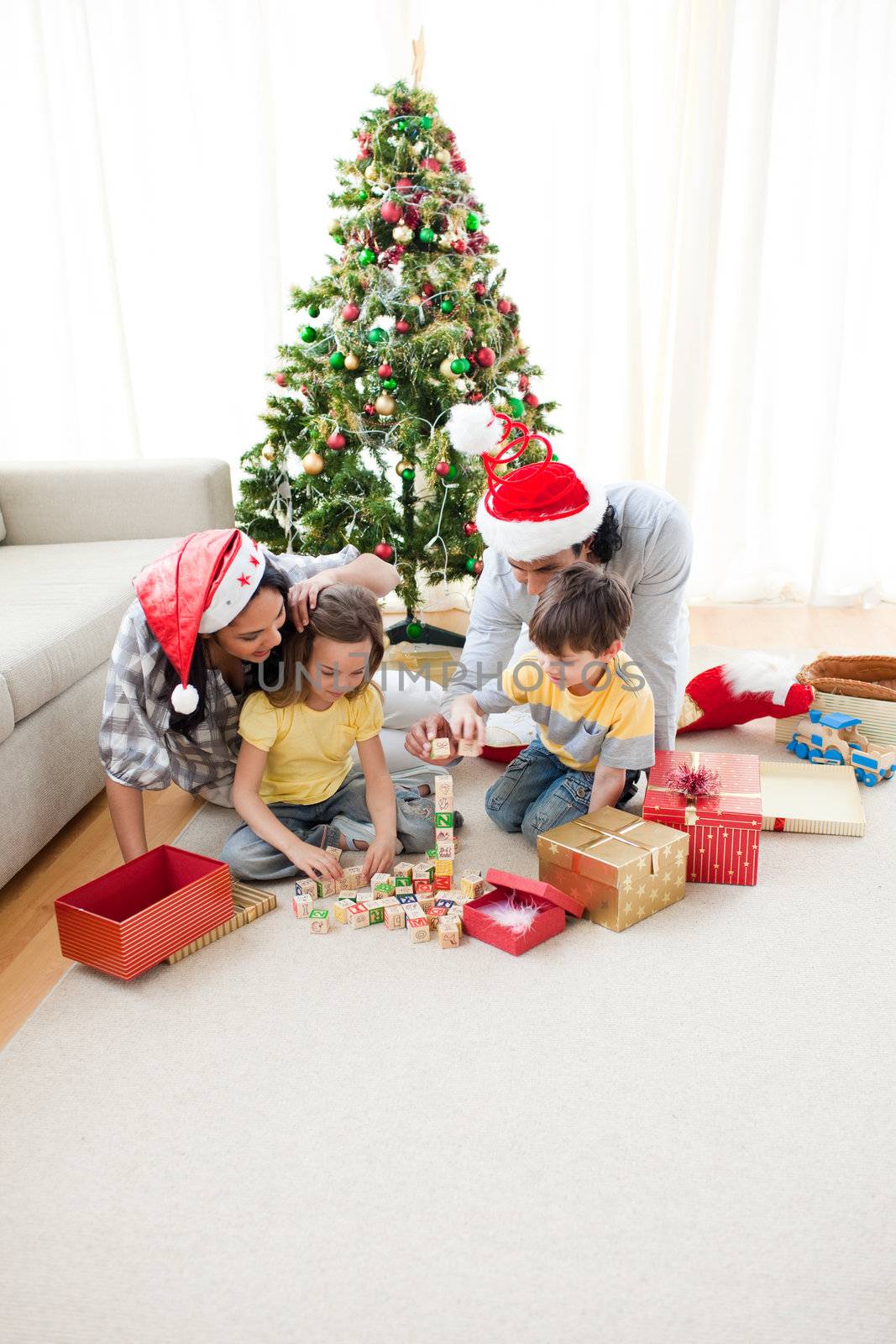 Family decorating a Christmas tree by Wavebreakmedia