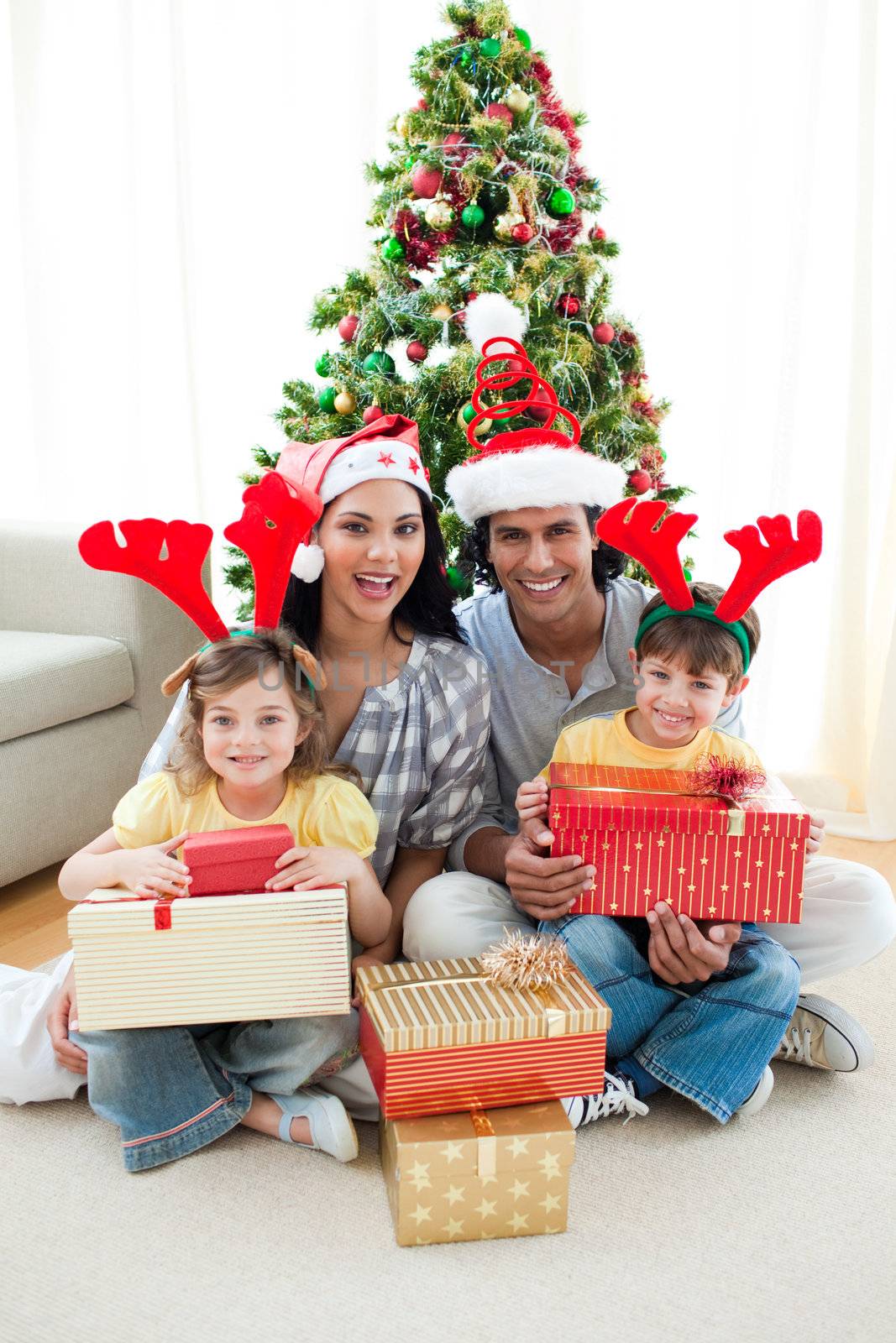 Family decorating a Christmas tree at home