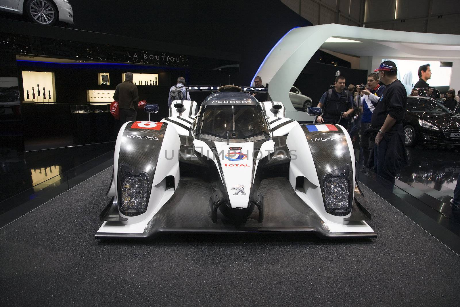 GENEVA, SWITZERLAND - MARCH 4, 2011 - Peugeot 908 Hybrid4 is presented at the annual motor show in Geneva on March 4, 2011.  This is Peugeot's entry for the 2011 edition of the 24 hour Le Mans race.  The car recovers and stores the kinetic energy generated when braking, and feeds it back into the driveline during acceleration.