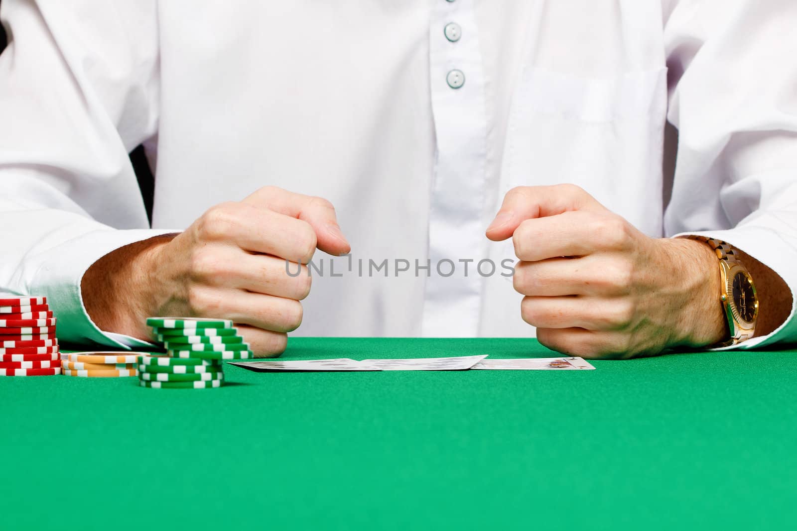 chips, cards and fists men in green game table in a casino