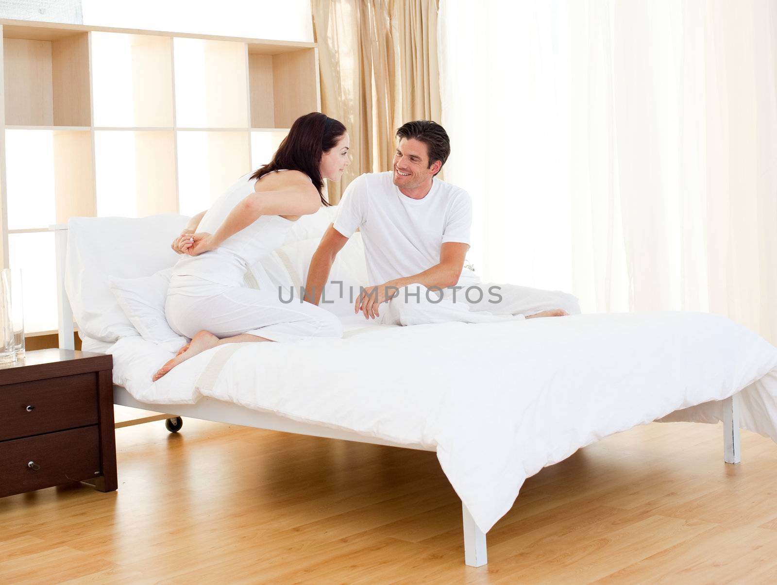 Romantic couple finding out pregnancy test sitting on the bed