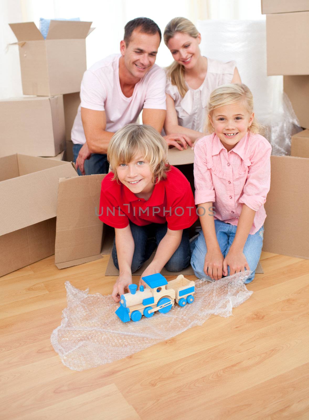 Cute children playing with a train while moving house