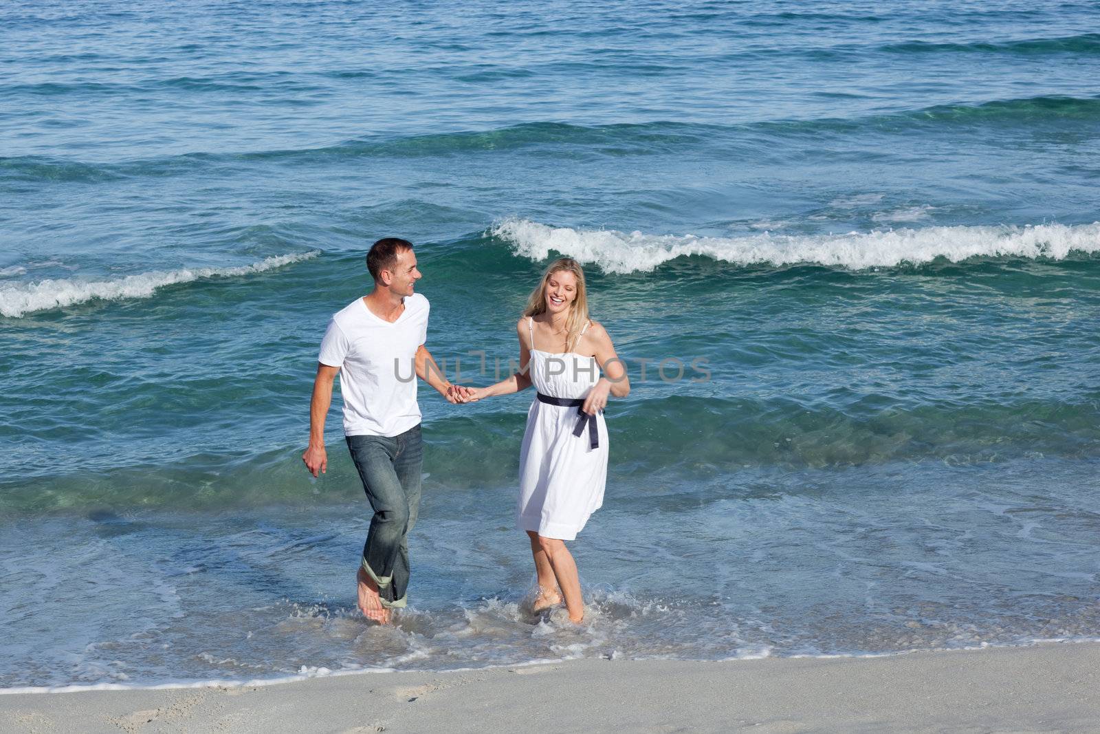 Romantic couple walking at the seaside by Wavebreakmedia
