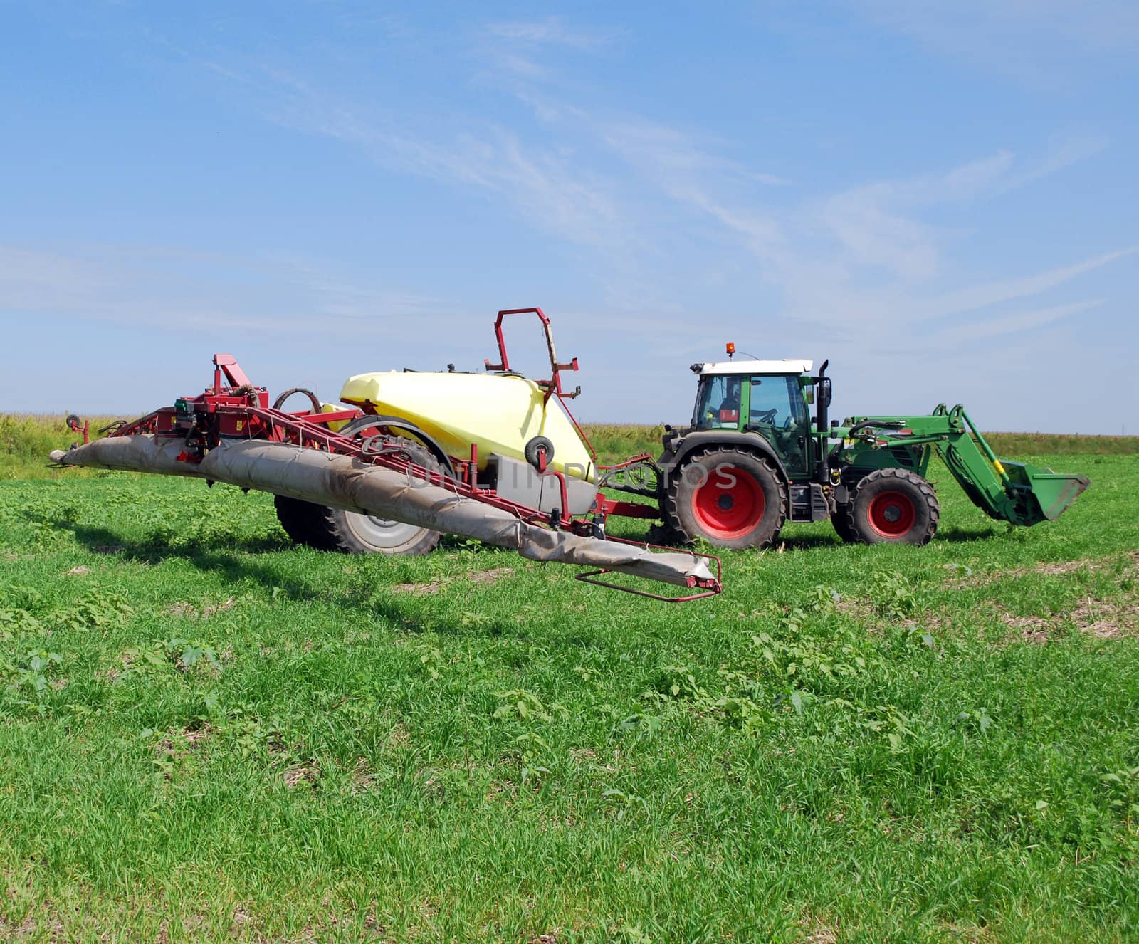 Tractor with sprayer on field