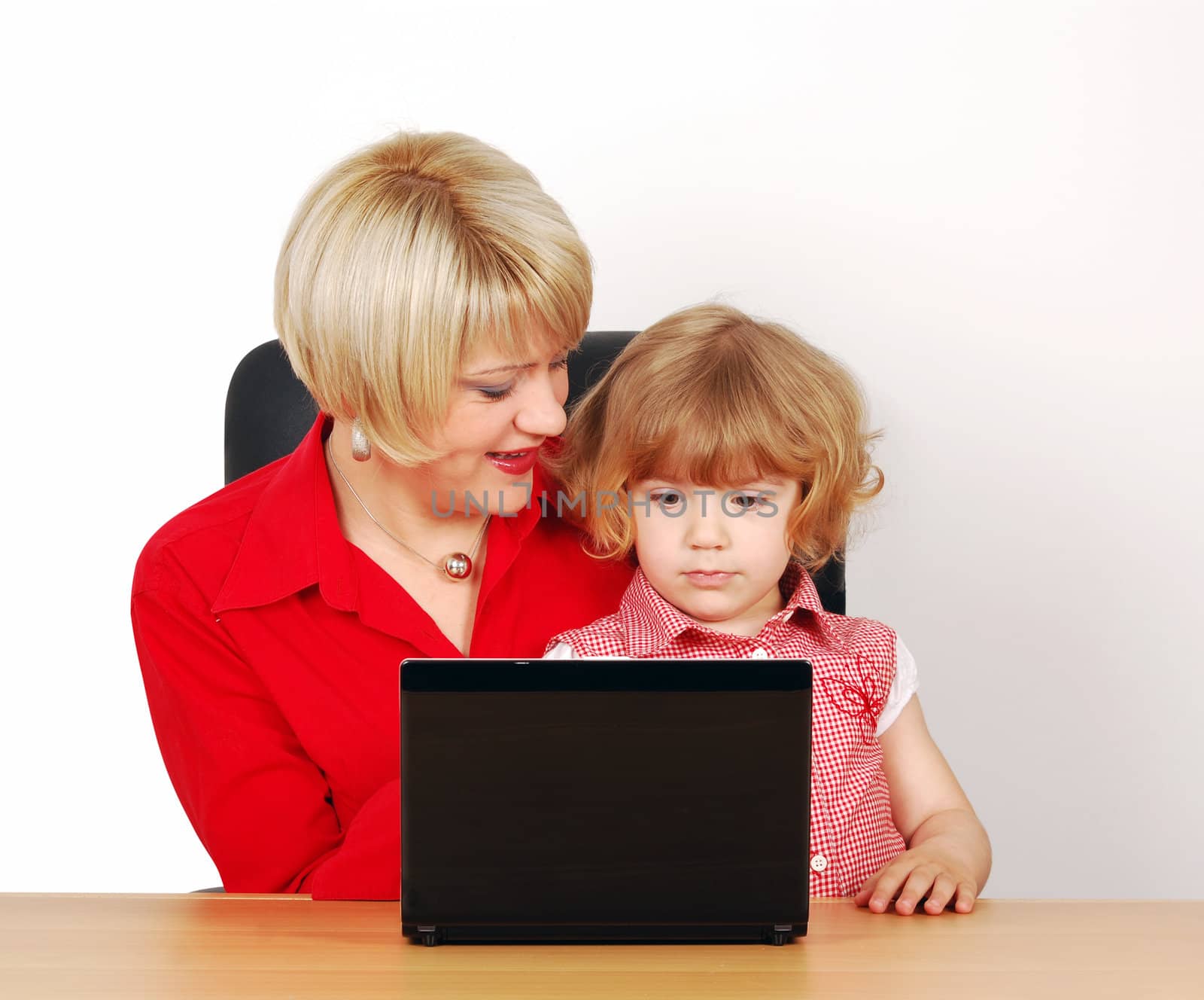 Woman and little girl with laptop studio shot