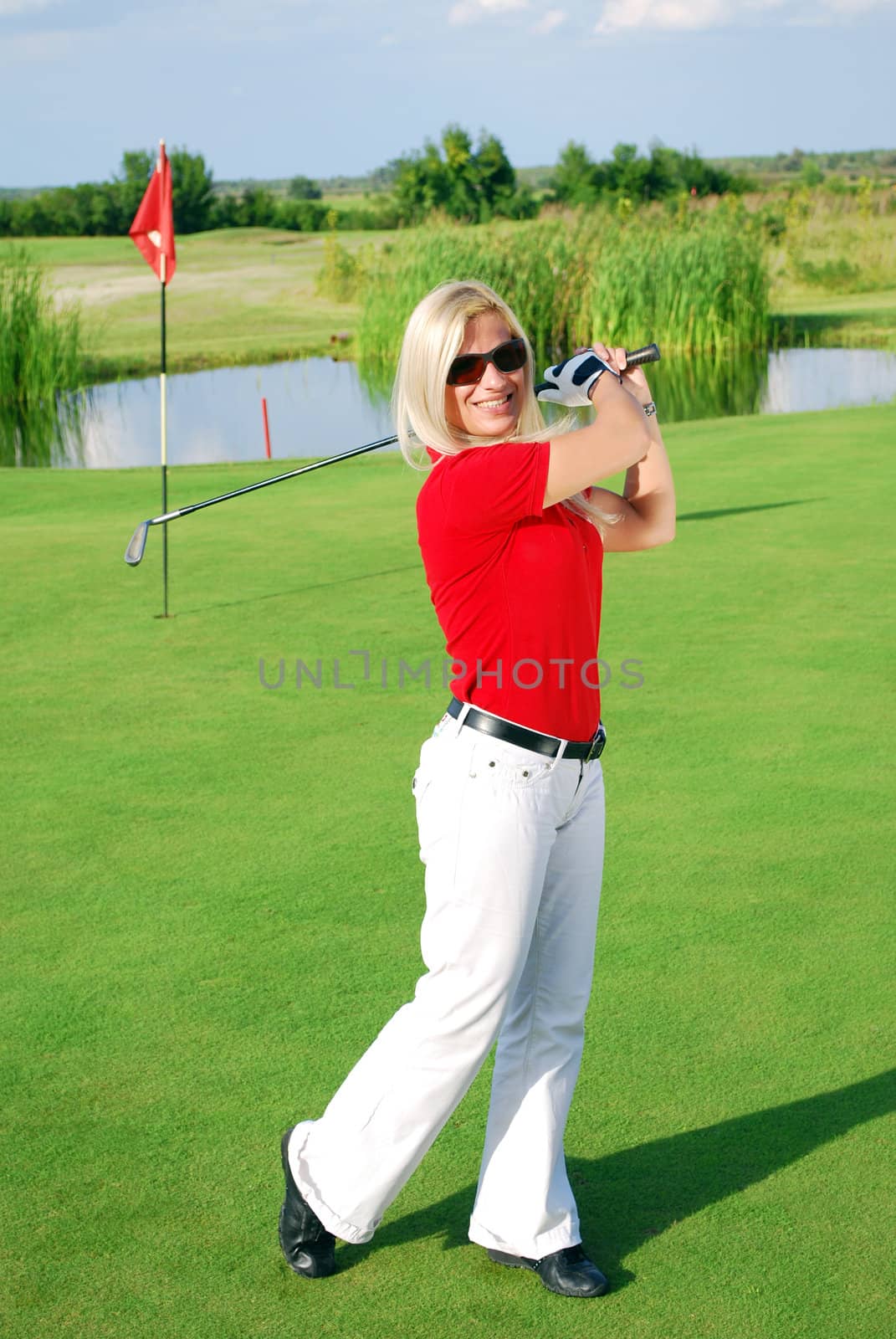 Happy blonde girl playing golf