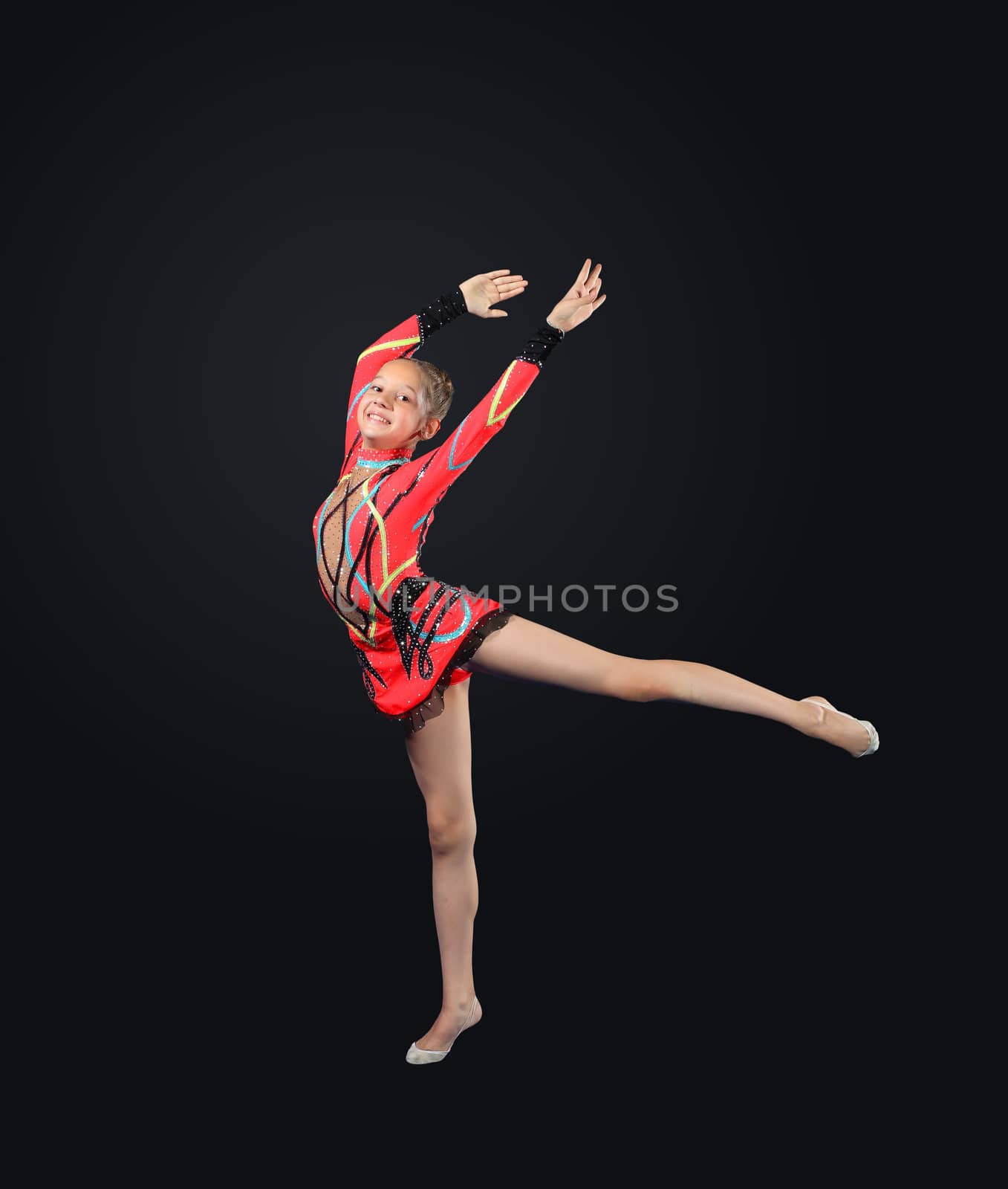 Young cute woman in gymnast suit show athletic skill on black background