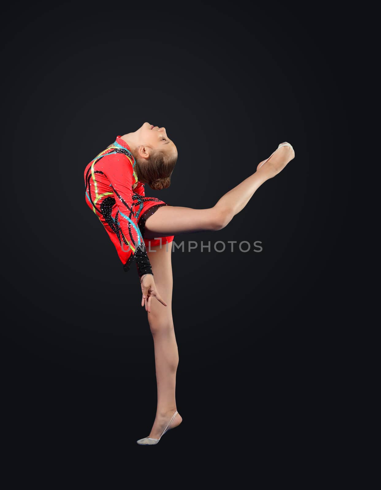 Young cute woman in gymnast suit show athletic skill on black background