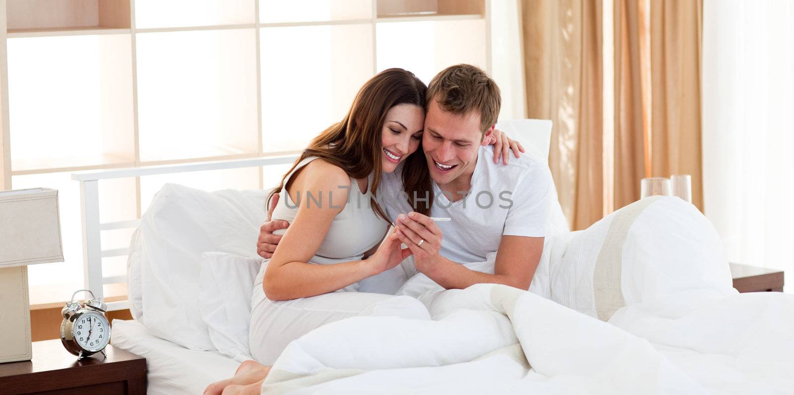 Merry couple finding out results of a pregnancy test by Wavebreakmedia