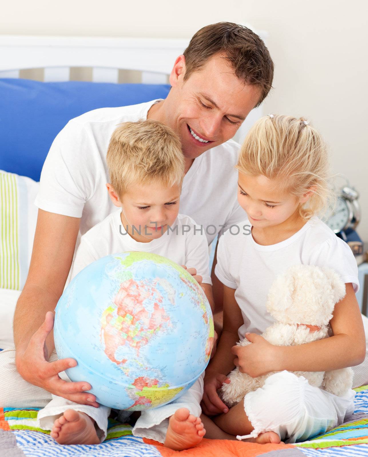 Adorable children and their father looking at a terrestrial glob by Wavebreakmedia