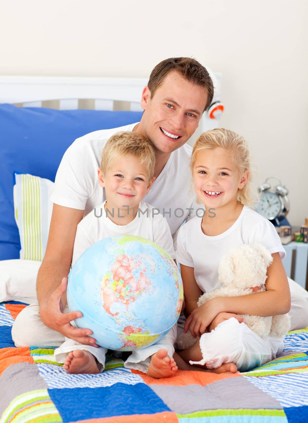 Cute children and their father looking at a terrestrial globe by Wavebreakmedia