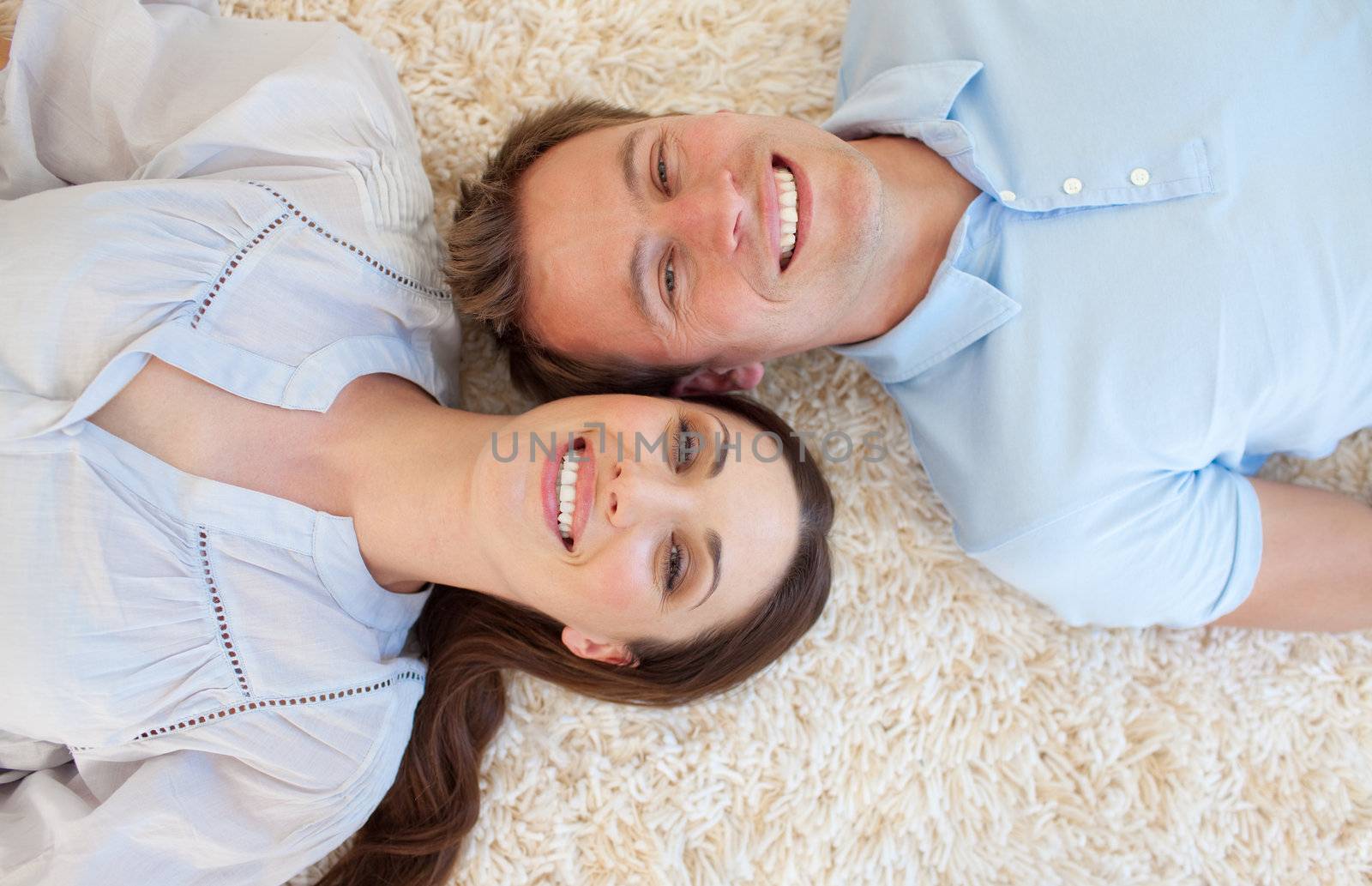 Romantic couple lying on the floor with heads together