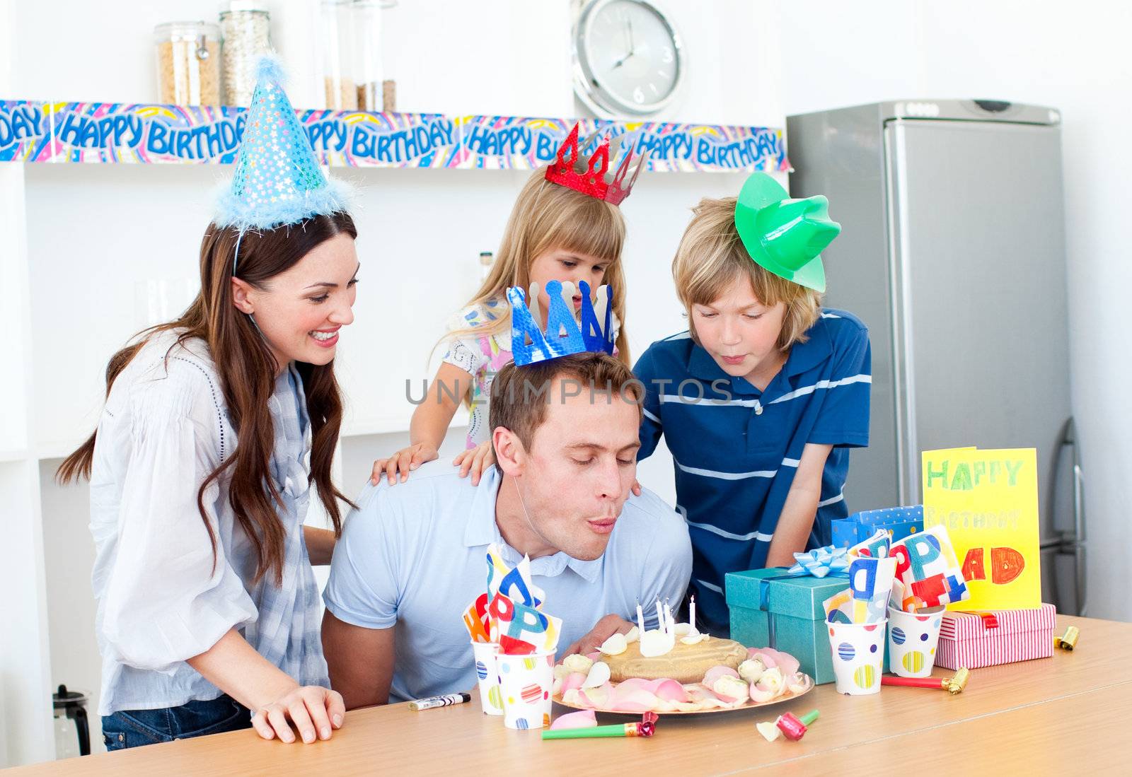 Elegant man celebrating his birthday with his wife and his child by Wavebreakmedia