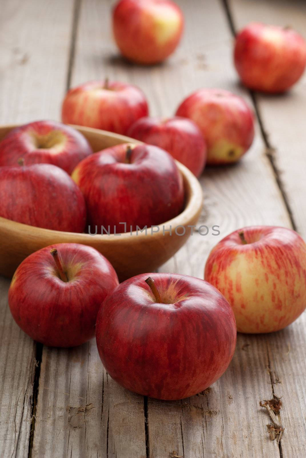 A bowl of red apples on the wooden table