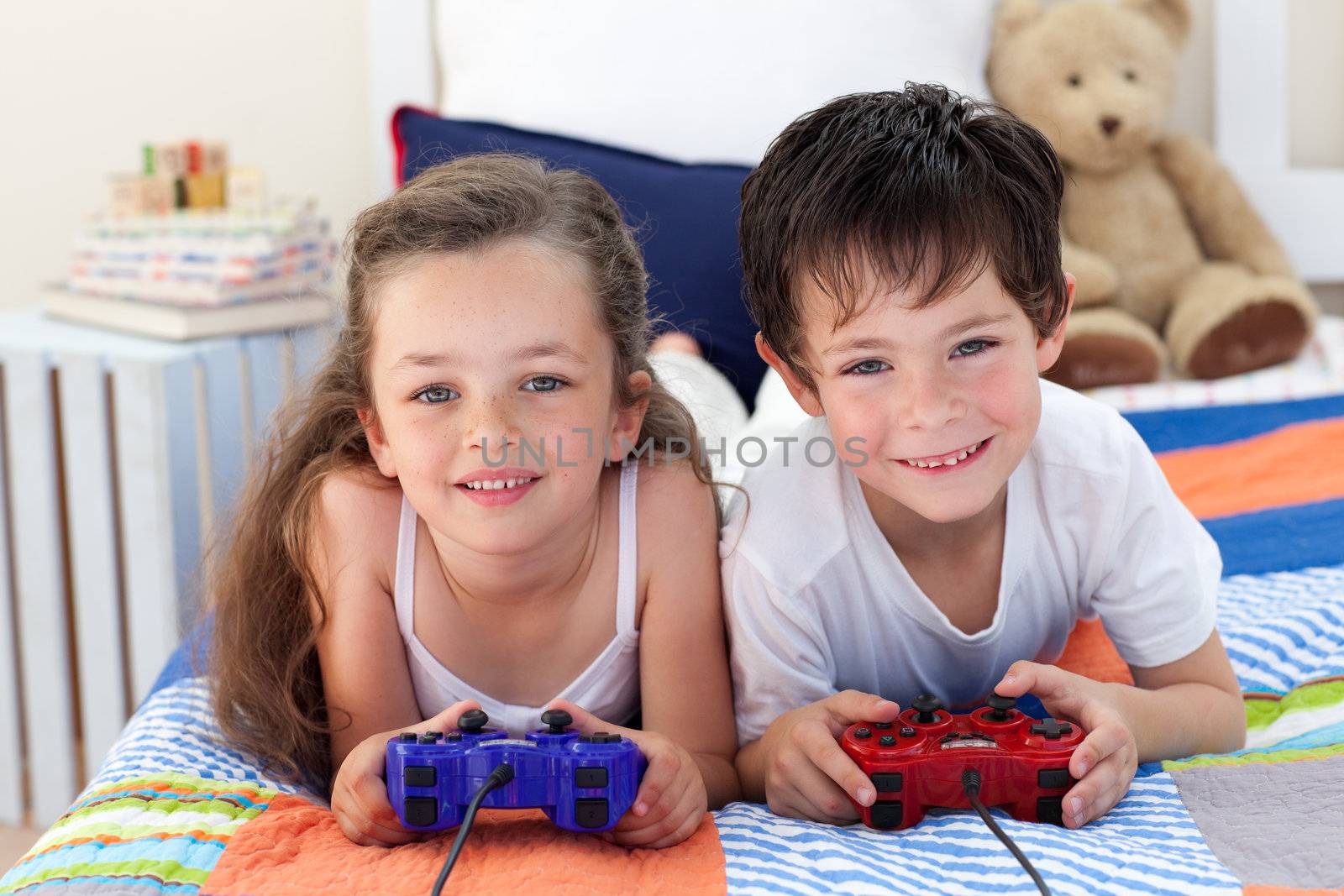 Siblings playing video games together by Wavebreakmedia