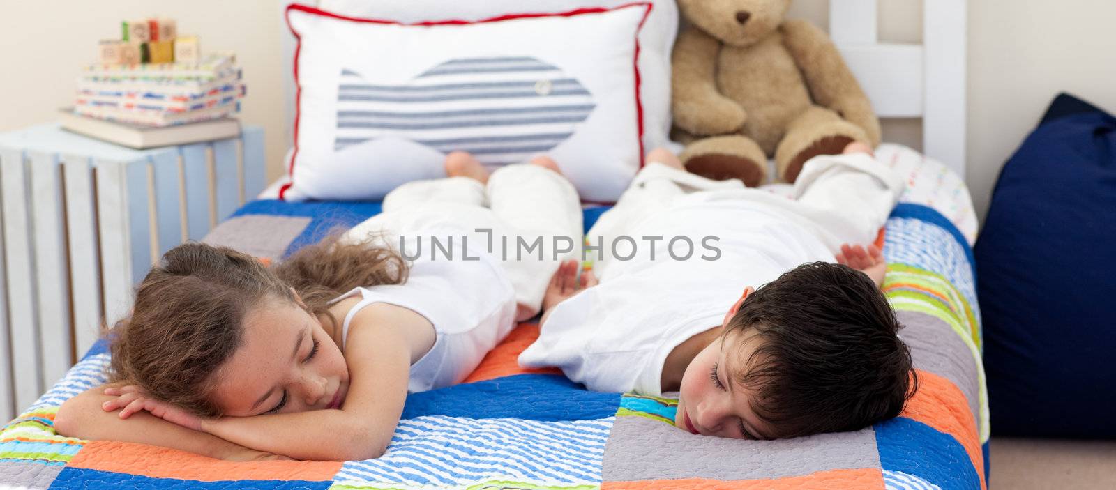 Cute Brother and sister sleeping on bed