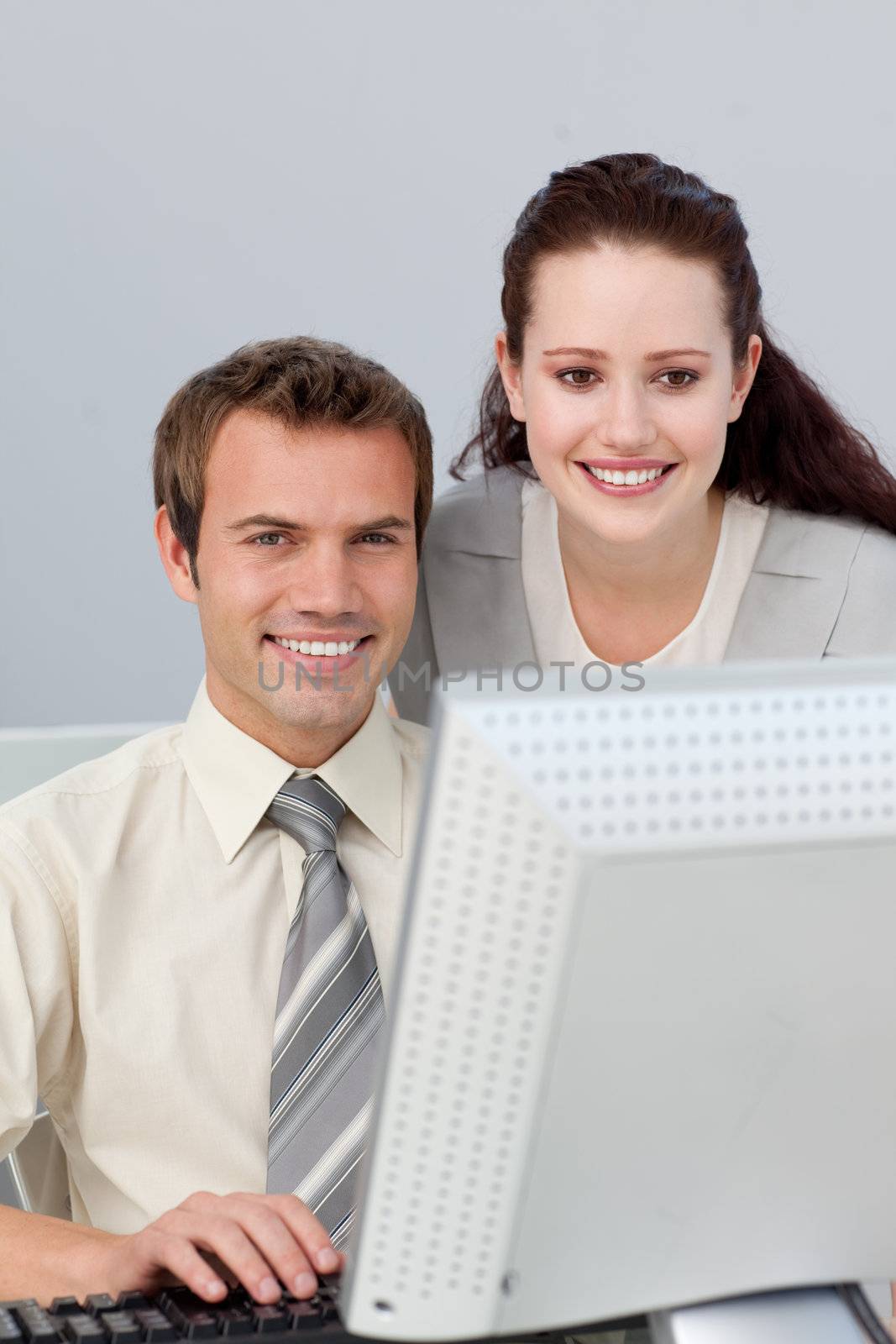 Confident businesswoman helping her colleague at a computer 