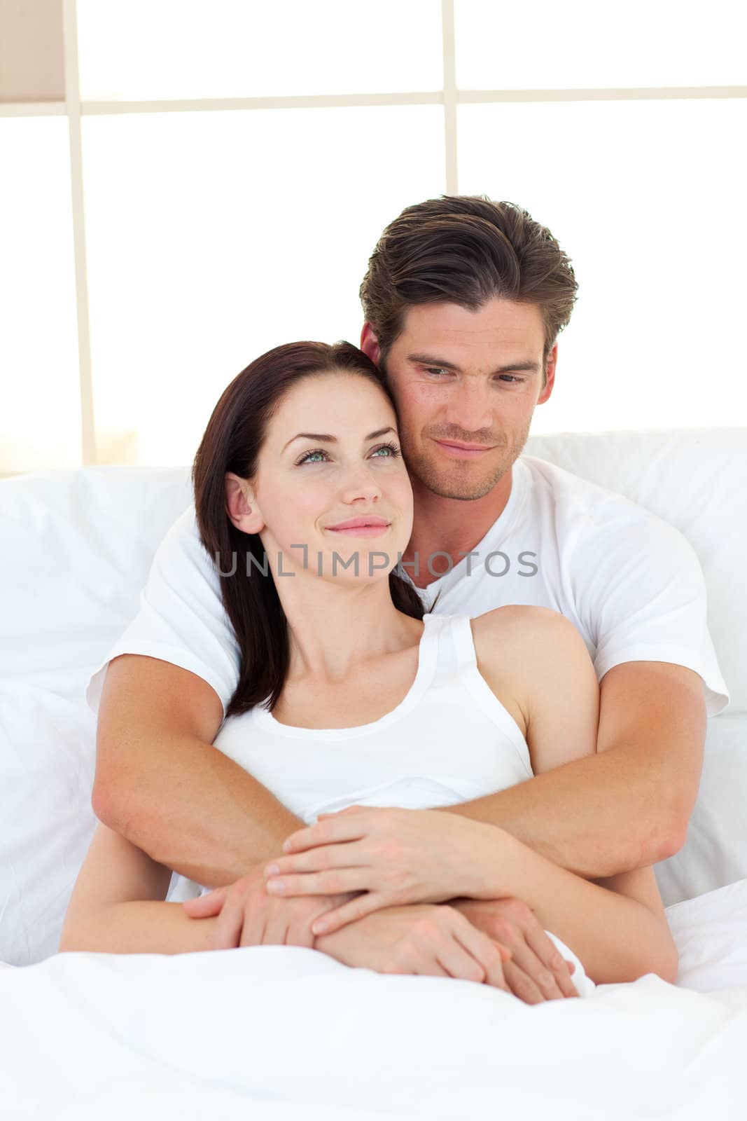 Portrait of happy lovers hugging in their bed by Wavebreakmedia