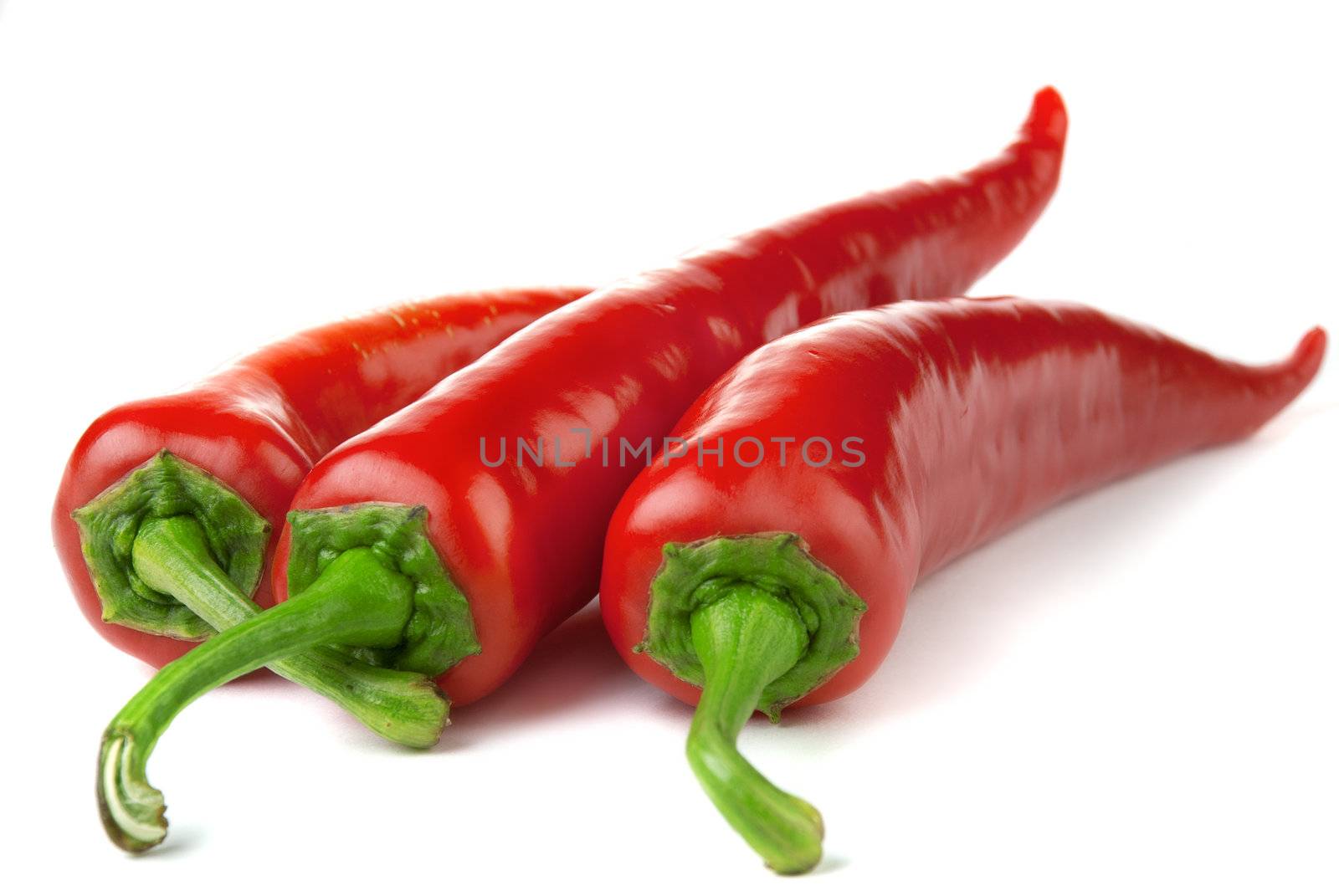 Three red chili peppers isolated on a white background