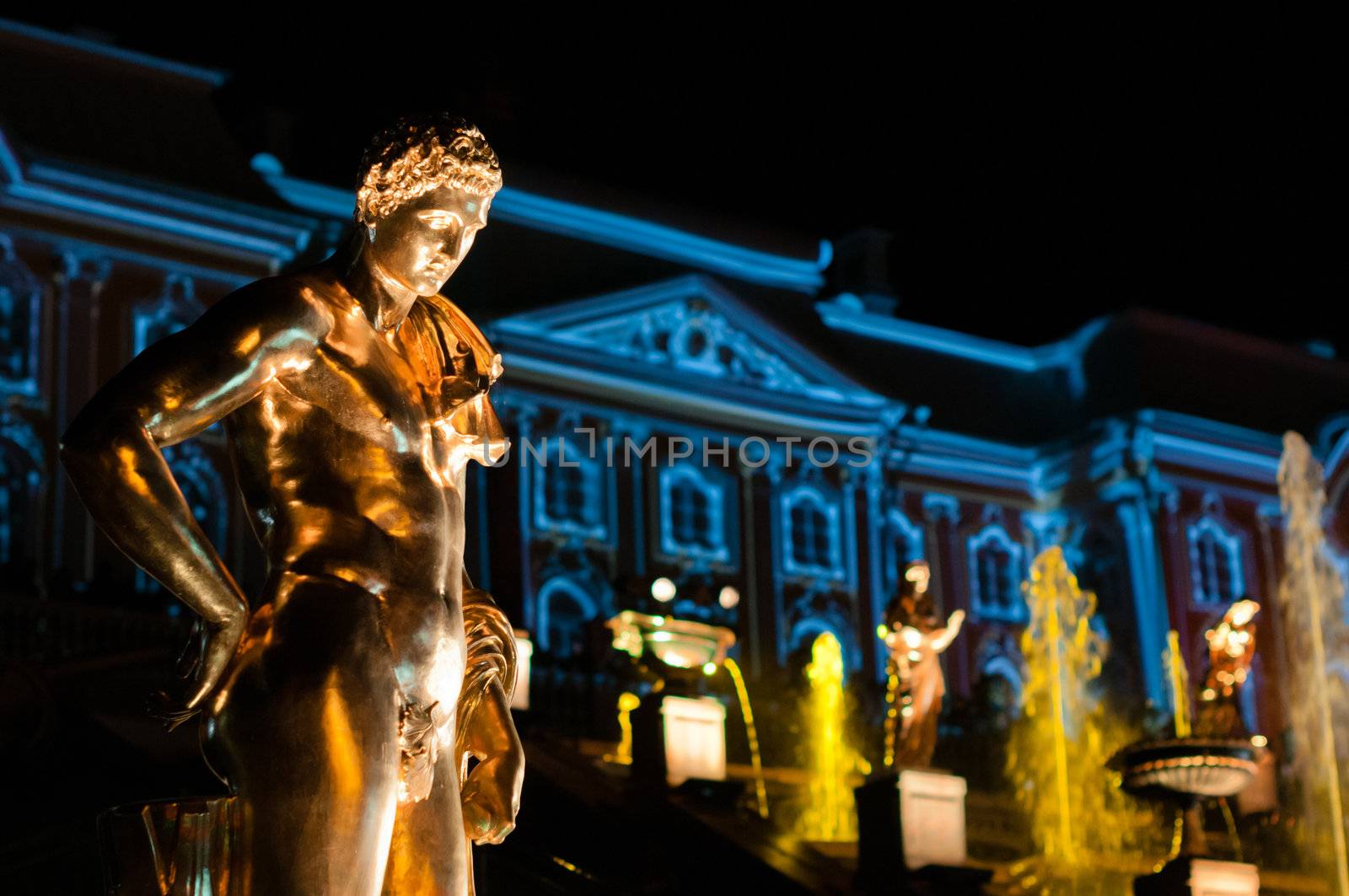 Sculpture with palace on background at night at Petergof, Russia