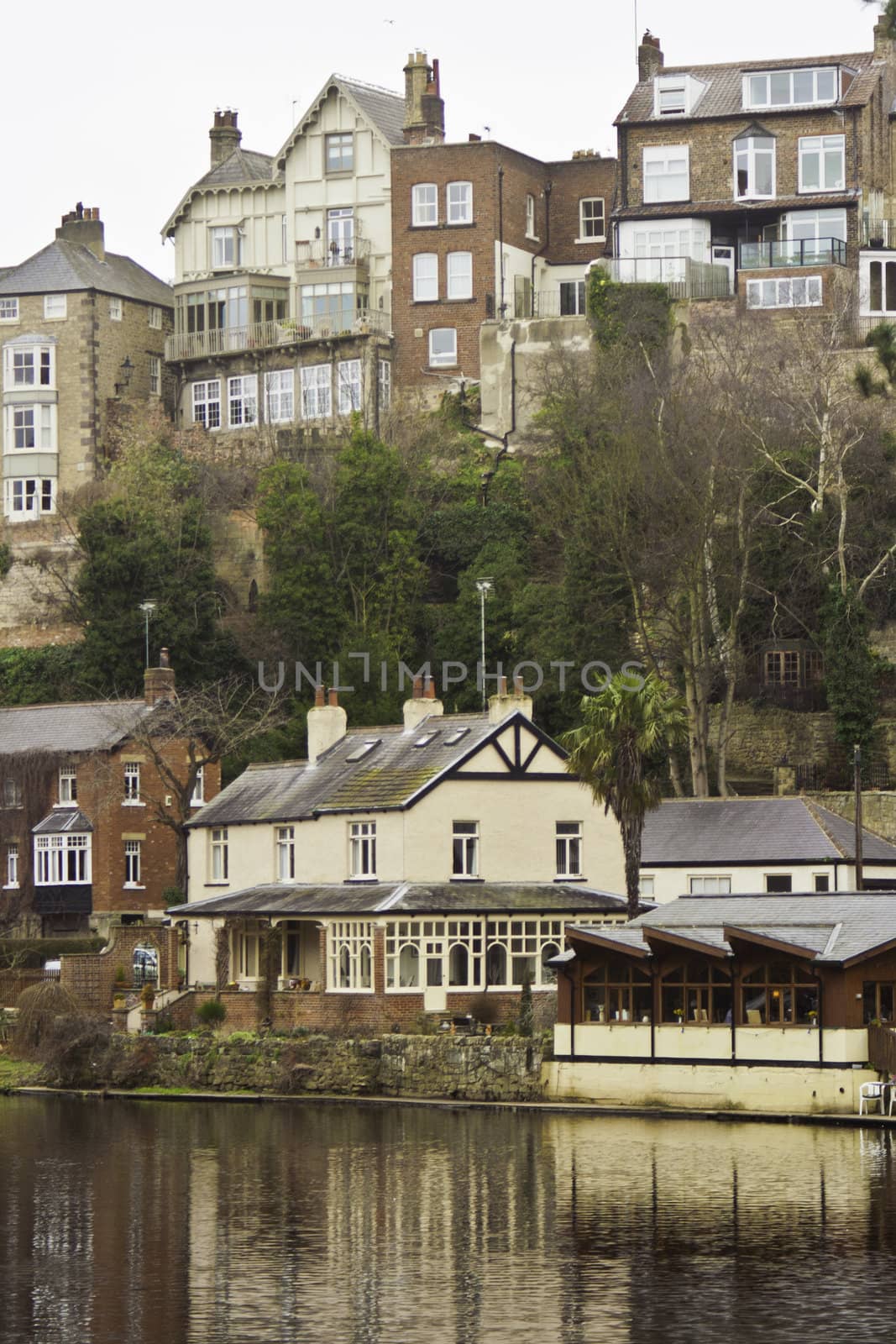 Town of Knaresborough, England, with its quiant historical houses reflected in the water of the river below