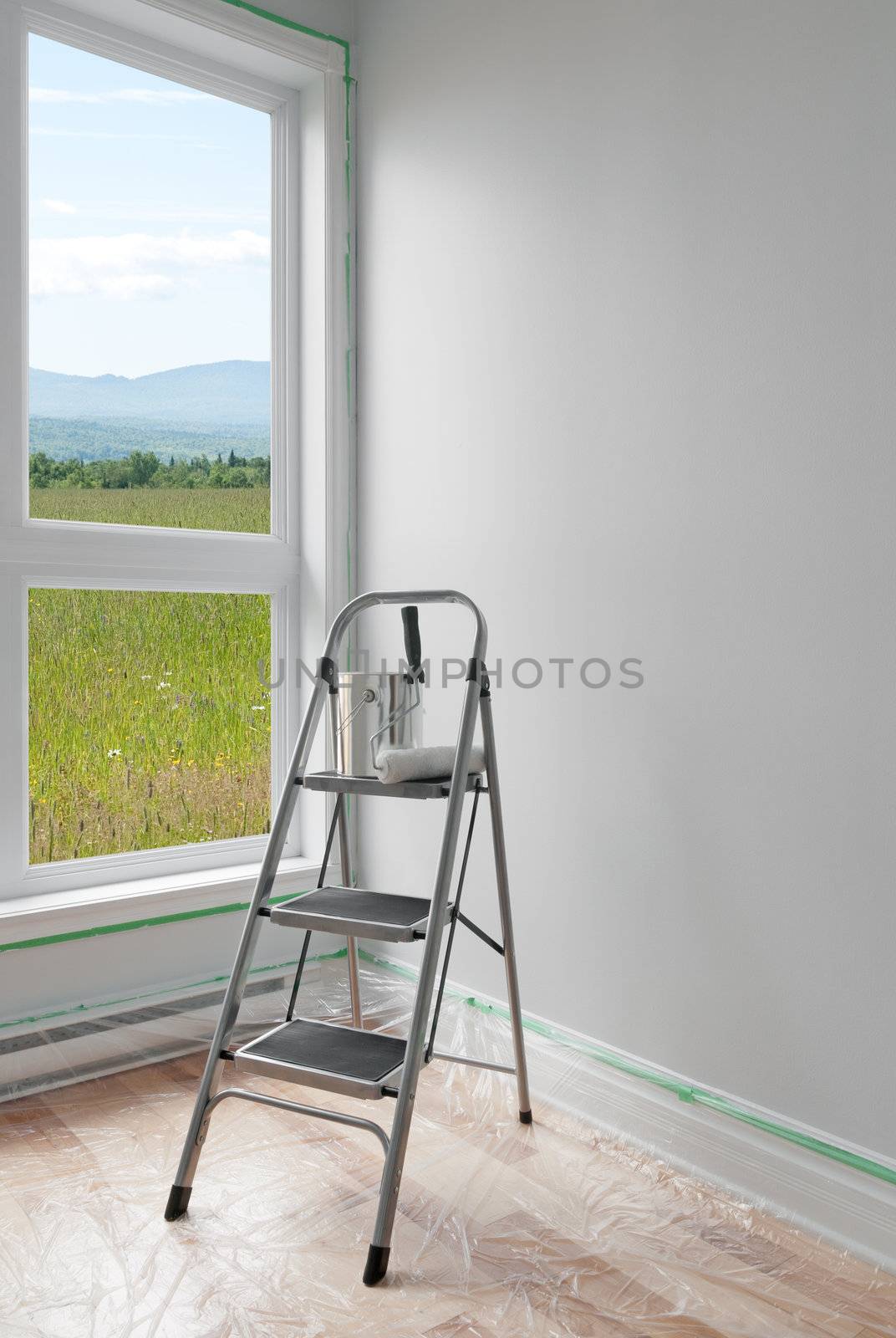 Renovations. Ladder and a can of paint in a room with beautiful view.