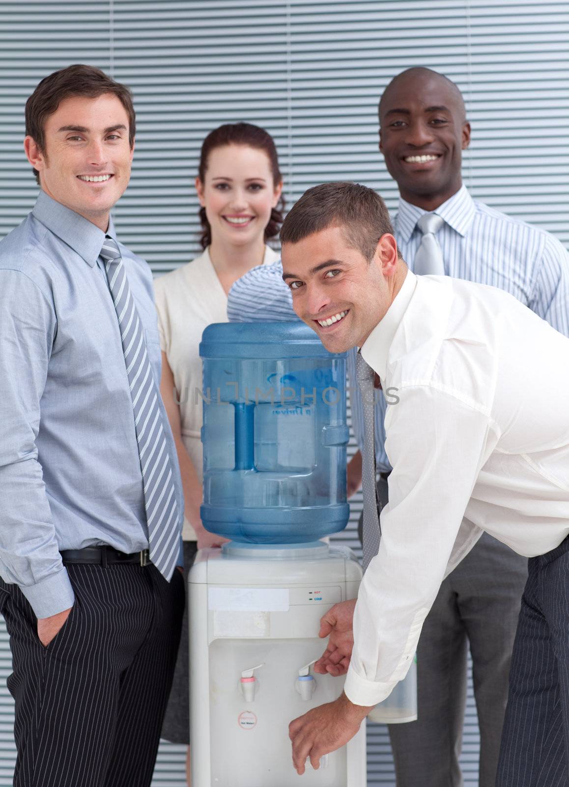 Busines people standing around water cooler in workplace