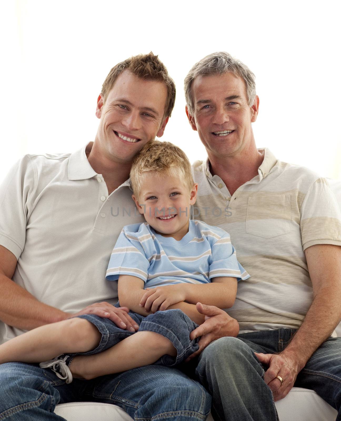 Smiling son, father and grandfather sitting on sofa by Wavebreakmedia