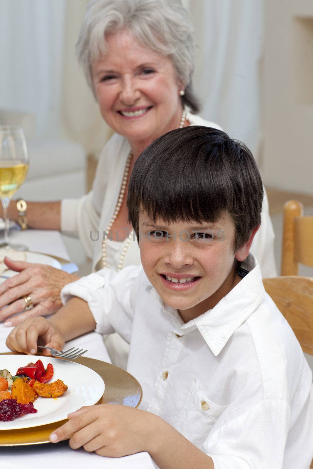 Smiling boy having dinner with his family by Wavebreakmedia