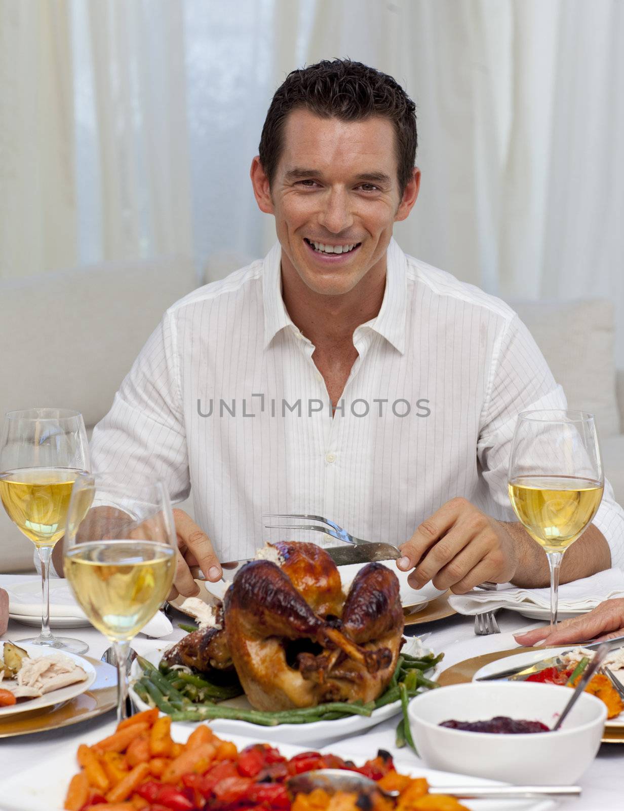 Smiling man eating turkey in Christmas dinner by Wavebreakmedia