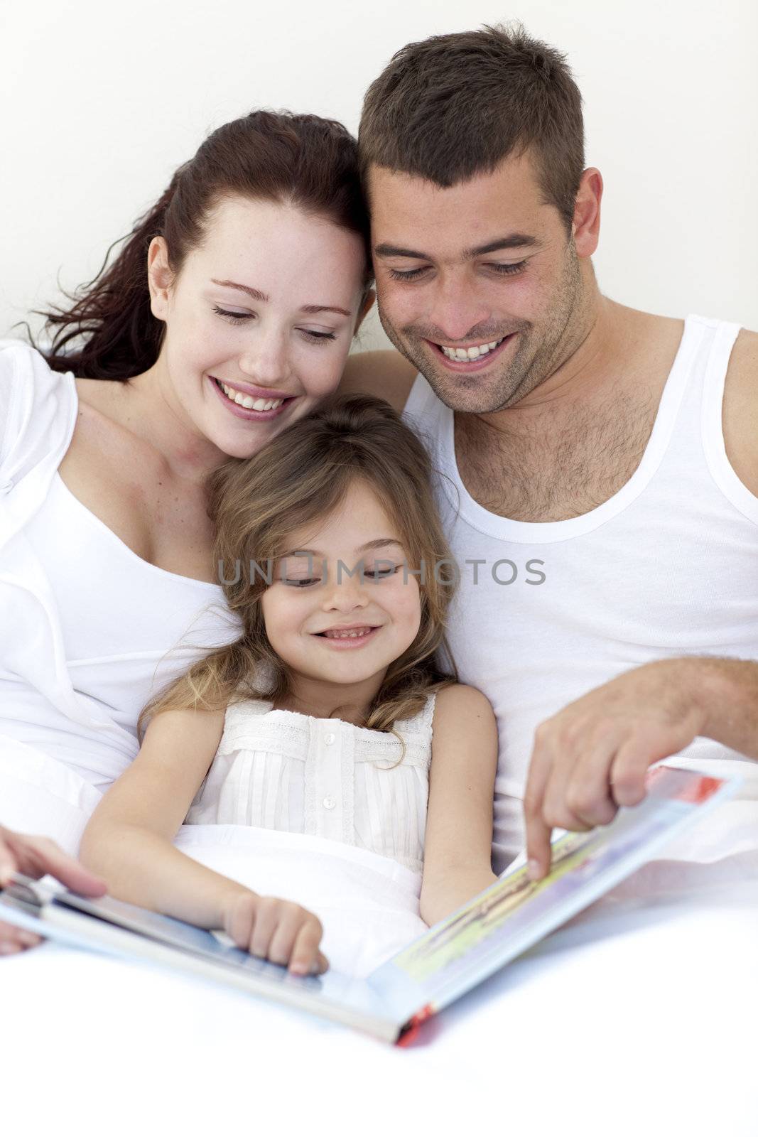 Young family reading in bed by Wavebreakmedia