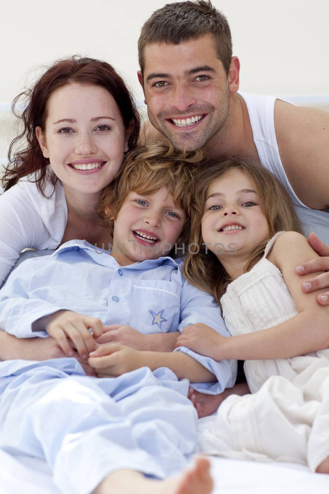 Portrait of parents and children lying together in bed